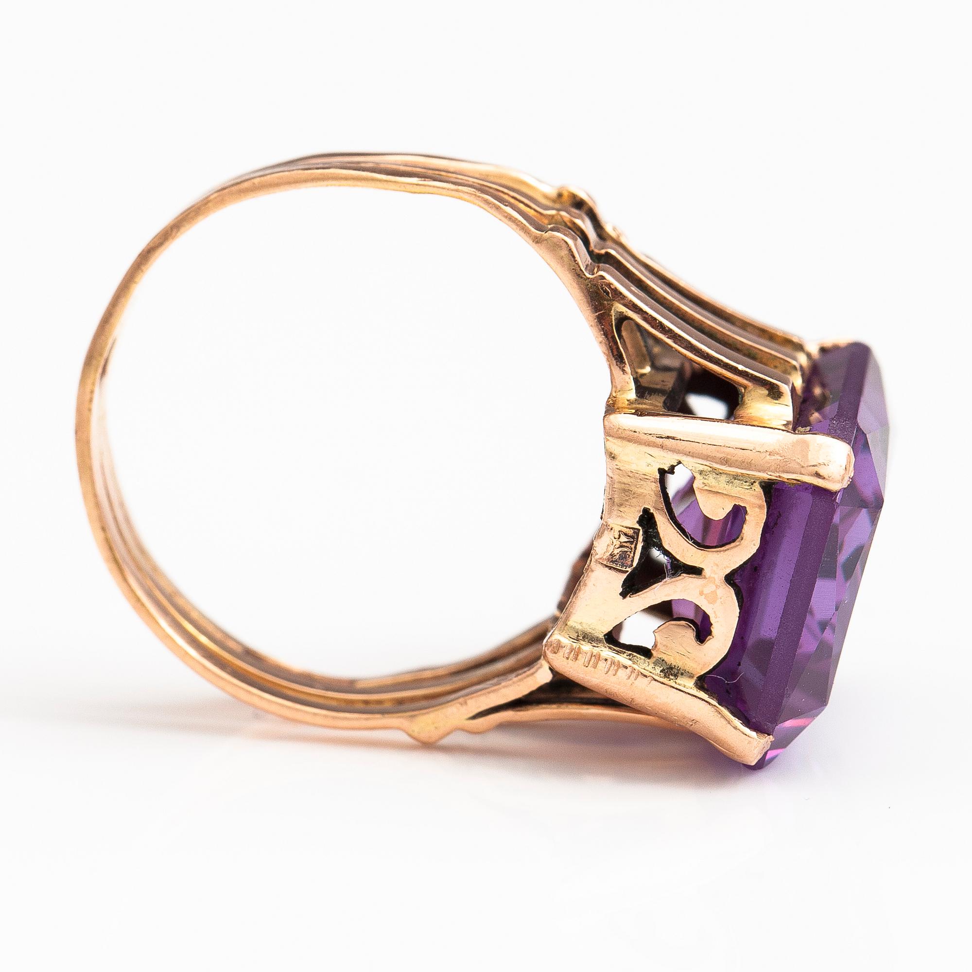A 9-14K gold ring with a synthetic sapphire.