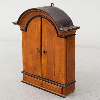 A first half of the 18th century late baroque elm veneered wall cabinet.