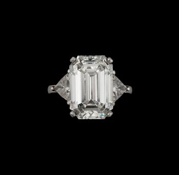 A baguette-cut diamond, 9.30 cts, ring. Quality I/VVS2. Flanked by two triangular diamonds approximately 1.00 ct each.