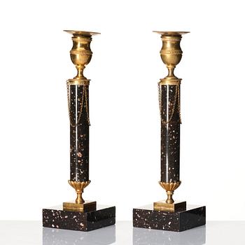 A pair of late Gustavian porphyry and gilt brass candlesticks, circa 1800.