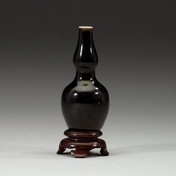 A black-glazed double gourd vase, Qing dynasty, 19th century.