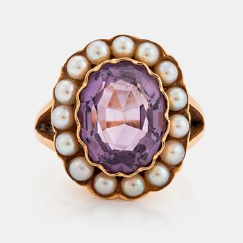 1046. An 18K gold ring set with a faceted amethyst and pearls.