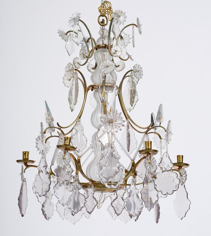 A near pair of rococo-style gilt brass and cut glass six-branch chandeliers, 19th century incorporating older elements.