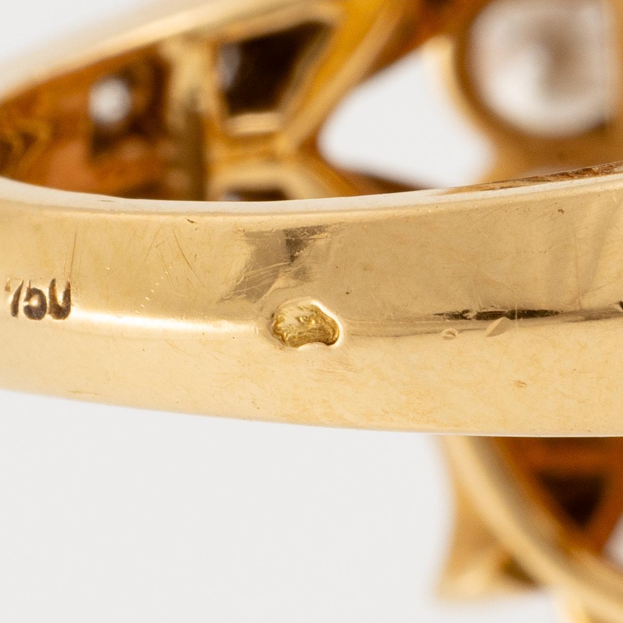 An 18K gold and coral Cartier ring set with round brilliant-cut diamonds.