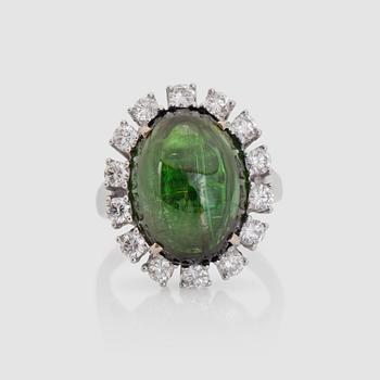 A cabochon-cut 10.94 ct green tourmaline and brilliant-cut diamond ring. Total carat weight of diamonds 1.02 cts.
