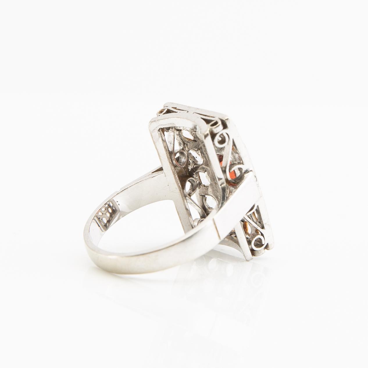 Ring, 18K white gold with a red stone (possibly garnet) and diamonds.