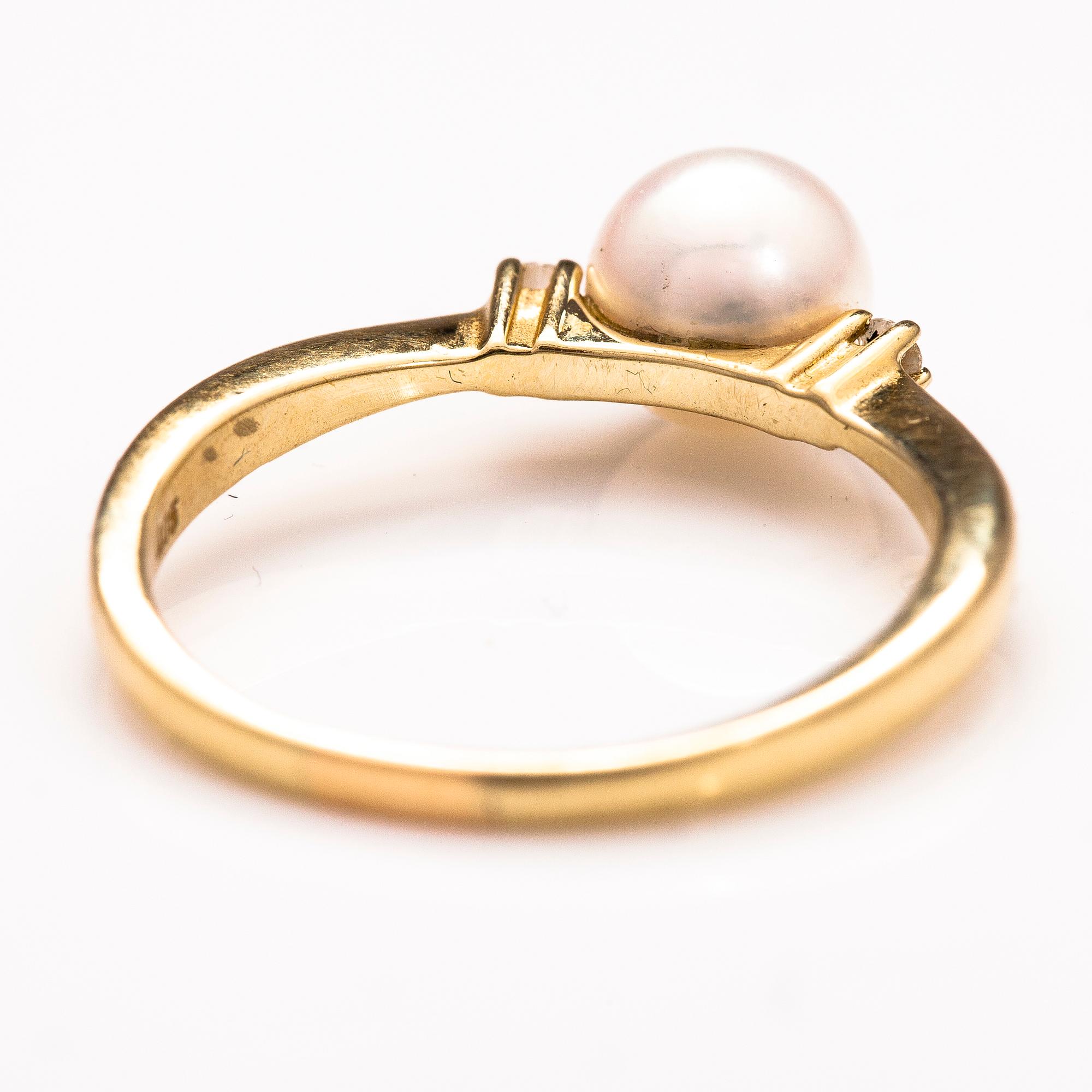 A 14K gold ring wirh diamonds ca 0.10 ct in total and a cultured pearl.
