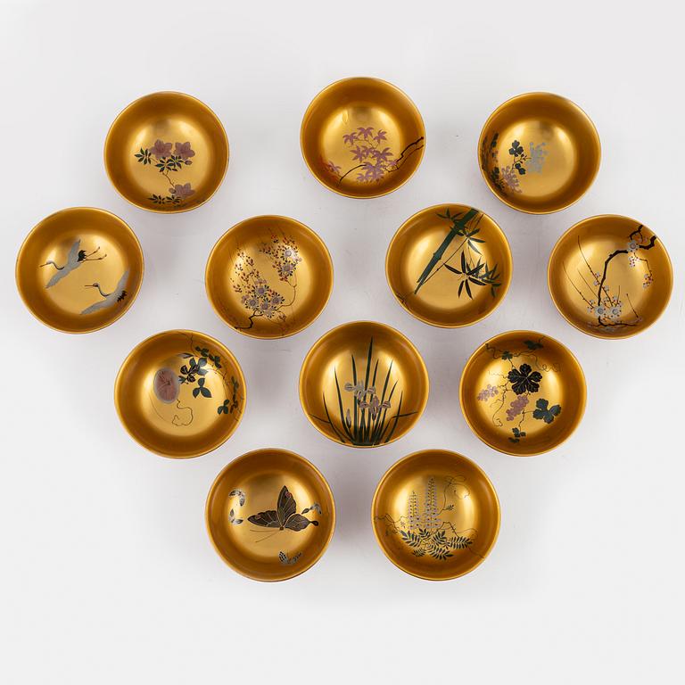 A silk clad box with twelve Japanese lacquer bowls, with dating inside the box 28/5 1930.