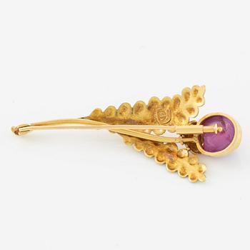 Brooch, 18K gold with cabochon-cut ruby, decoration of leaves.