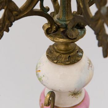 A pair of gilt-bronze Rococo Revival candelabra with porcelain decors, from the latter half of the 19th century.