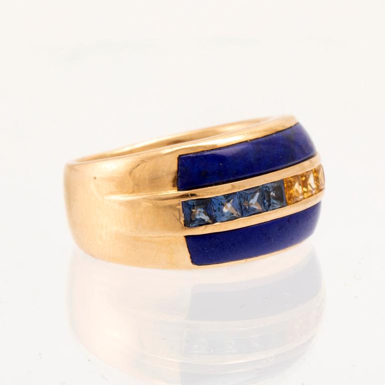 An 18K gold ring set with princess-cut blue and yellow, likely, sapphires as well as Lapis Lazuli.