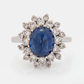 1026. An 18K white gold ring set with a cabochon-cut sapphire ca 4.00 cts and round brilliant-cut diamonds.