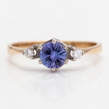 An 18K white gold ring, with a tanzanite and diamonds totalling approximately 0.04 ct.