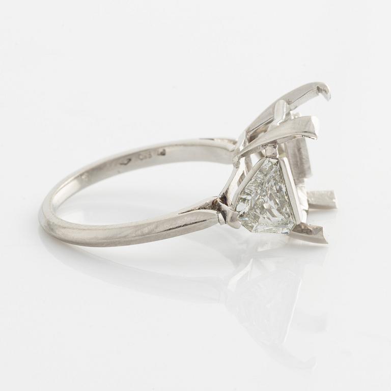 A platinum ring with and empty setting and with two triangular step cut diamonds.