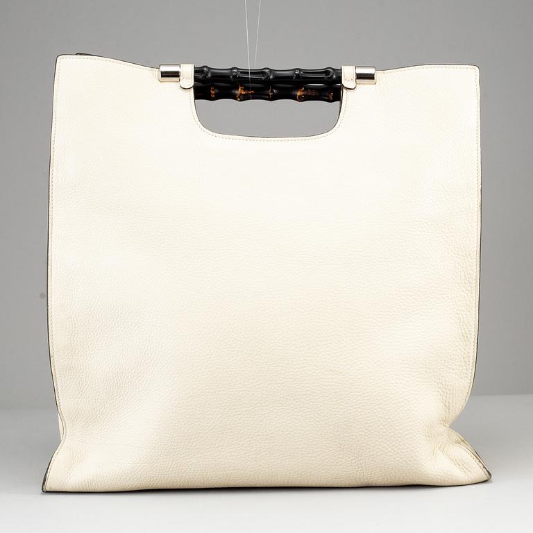 GUCCI, a white leather tote bag with bamboo handles.