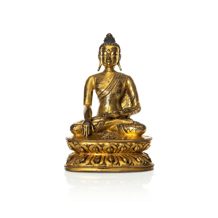 A gilt copper-alloy figure of Aksobhya Buddha, 14th/15th century, Tibet or Nepal.