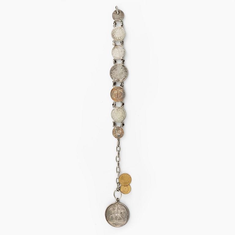 Two bracelets, a brooch, and a pendant with coins.