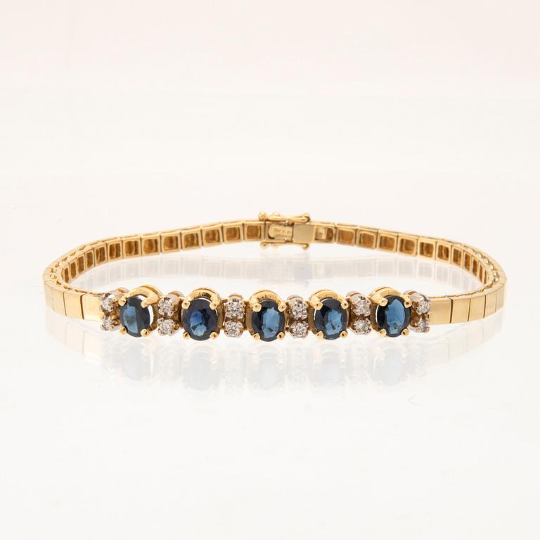 An 18K white and yellow gold bracelet set with oval-cut sapphires and round brilliant-cut diamonds.