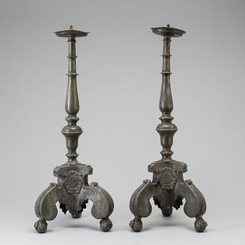 A pair of baroque pewter candlesticks, engraved date 1699.