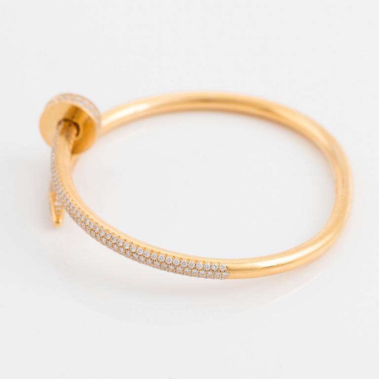 A Cartier "Juste un Clou" bracelet in 18K gold set with round brilliant-cut diamonds.