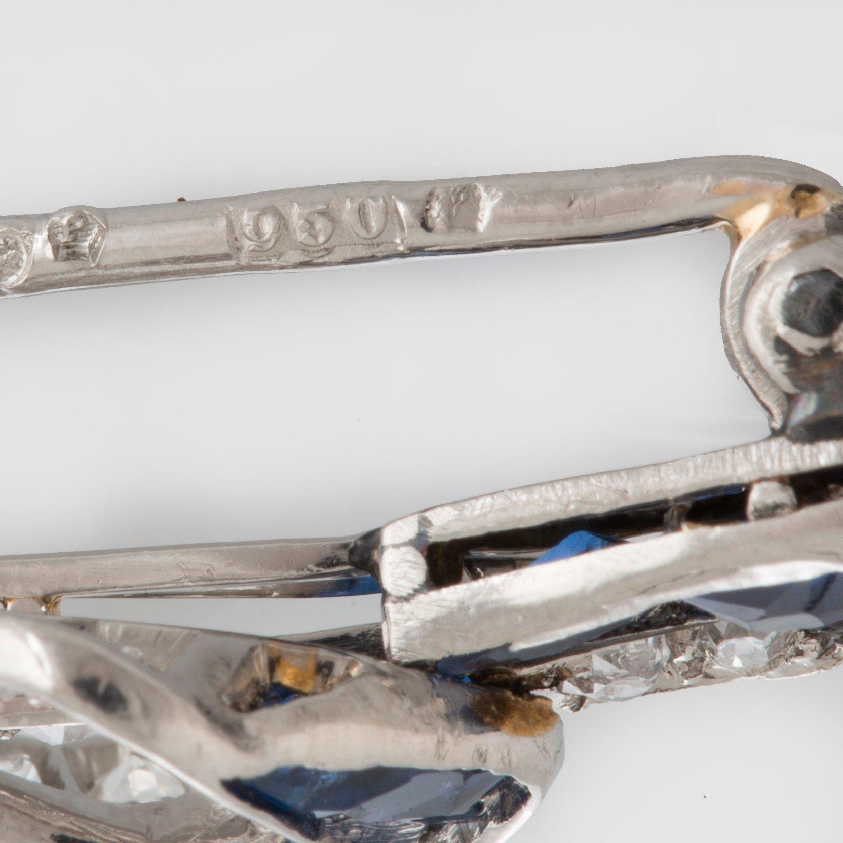A platinum brooch set with old-cut diamonds and faceted sapphires.