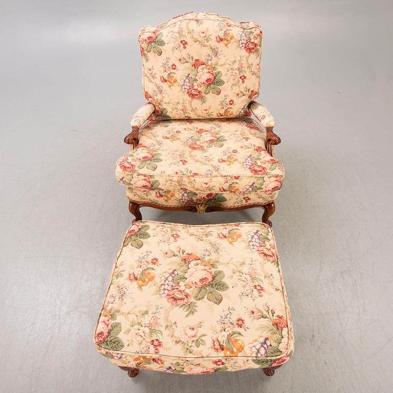 A Louis XV-style armchair and footstool later part of the 20th century.