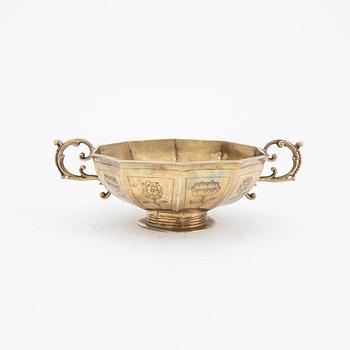 A silver guilt bowl with handles.