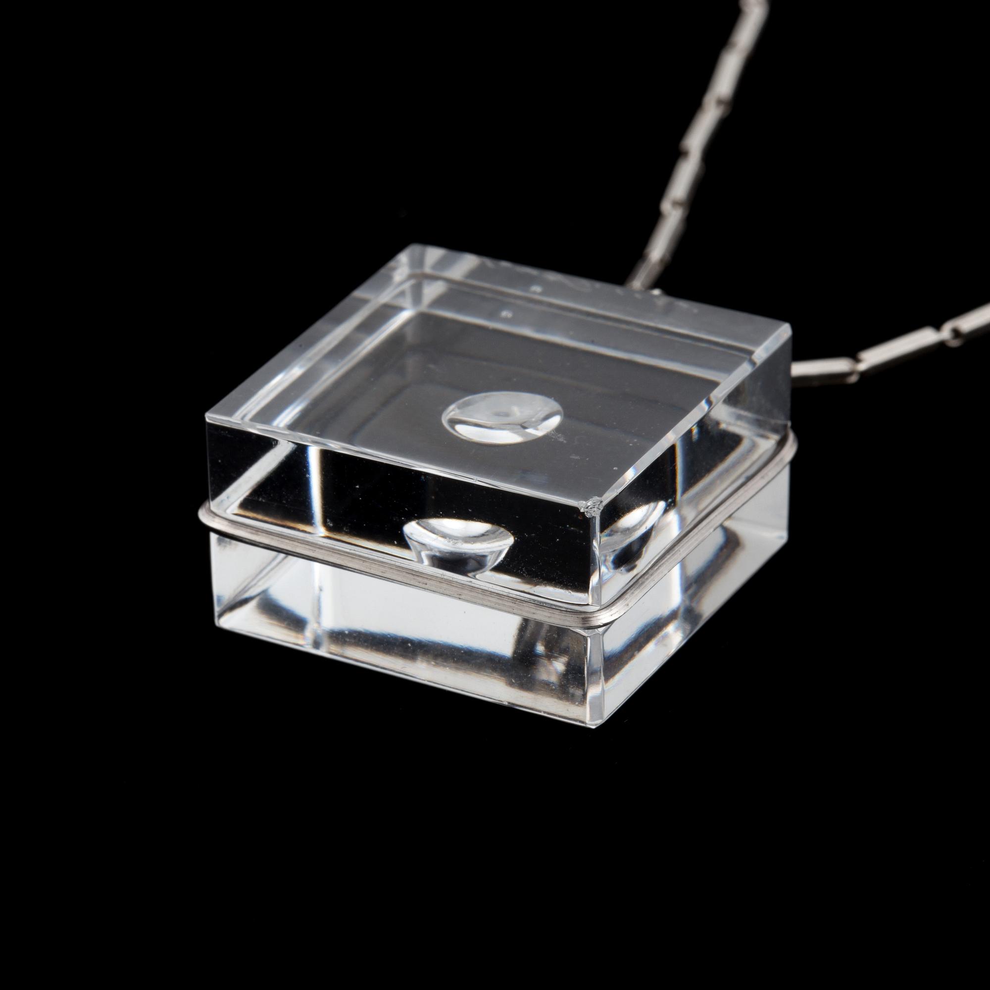 A glass pendant designed by Gunnar Cyrén and a silver necklace.