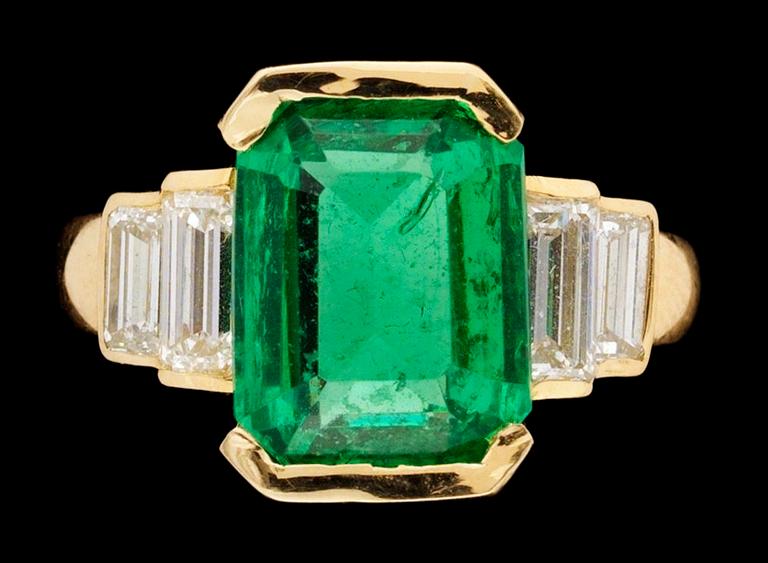 A gold, emerald and diamond ring.