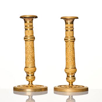 A pair of French gilded Empire candlesticks, early 19th century.