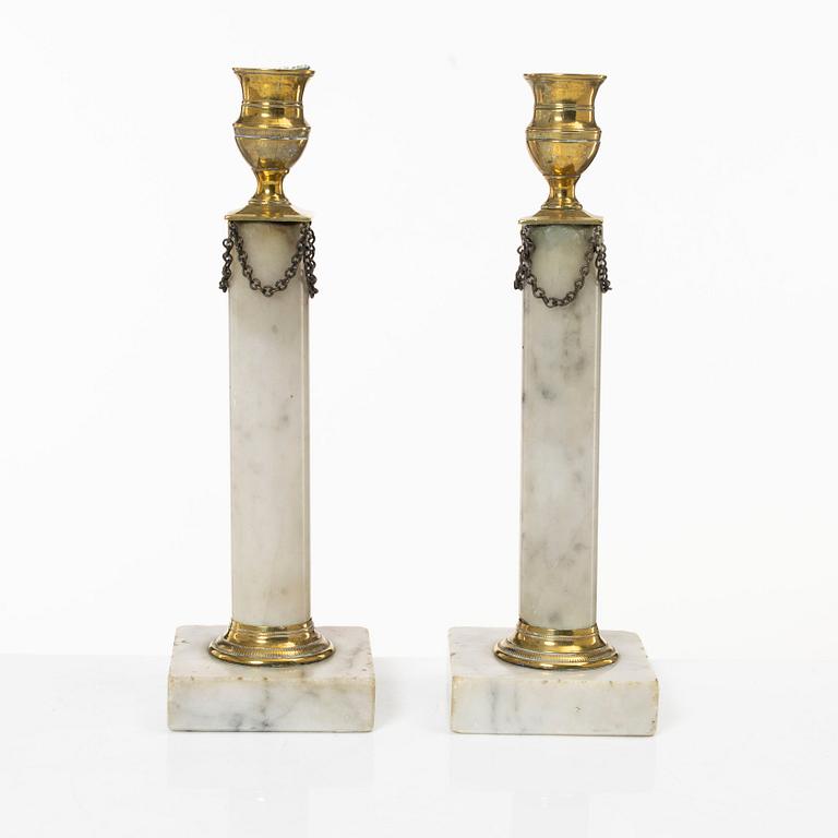 A pair of Gustavian brass and marble candlesticks, circa 1800.