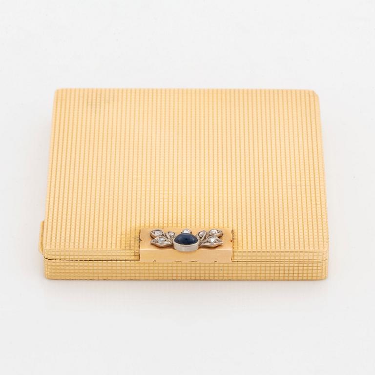 An 18K gold WA Bolin powder case set with a cabochon-cut sapphire and rose-cut diamonds.