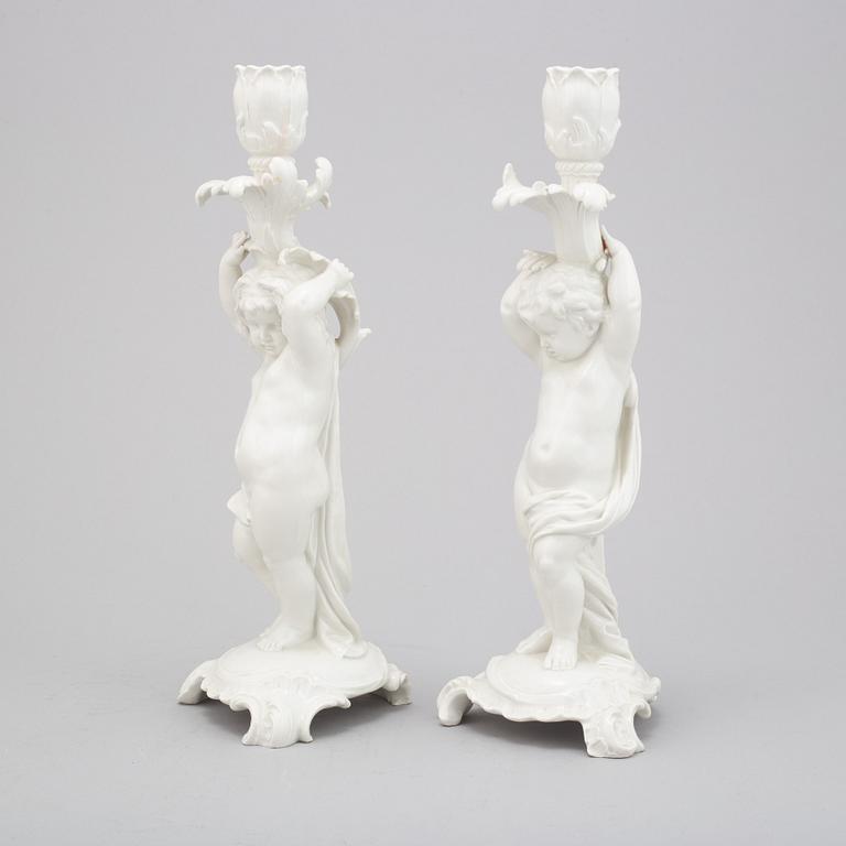 A German white glazed figure group and a pair of Berlin candle sticks, 20th Century.