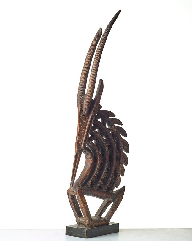 A SCULPTURE, a headdress, Tshiwara/Ciwara (stylized male antelope), wood, the Bambara tribe, Mali, h. 94 cm. On a base.