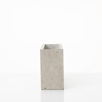 Stina Lindholm, a contemporary concrete planter 'Spira', a concrete flower pot and a wall clock.