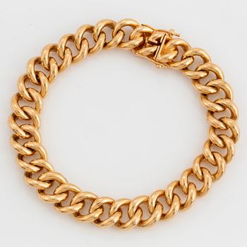 1043. An 18K gold curb link bracelet.