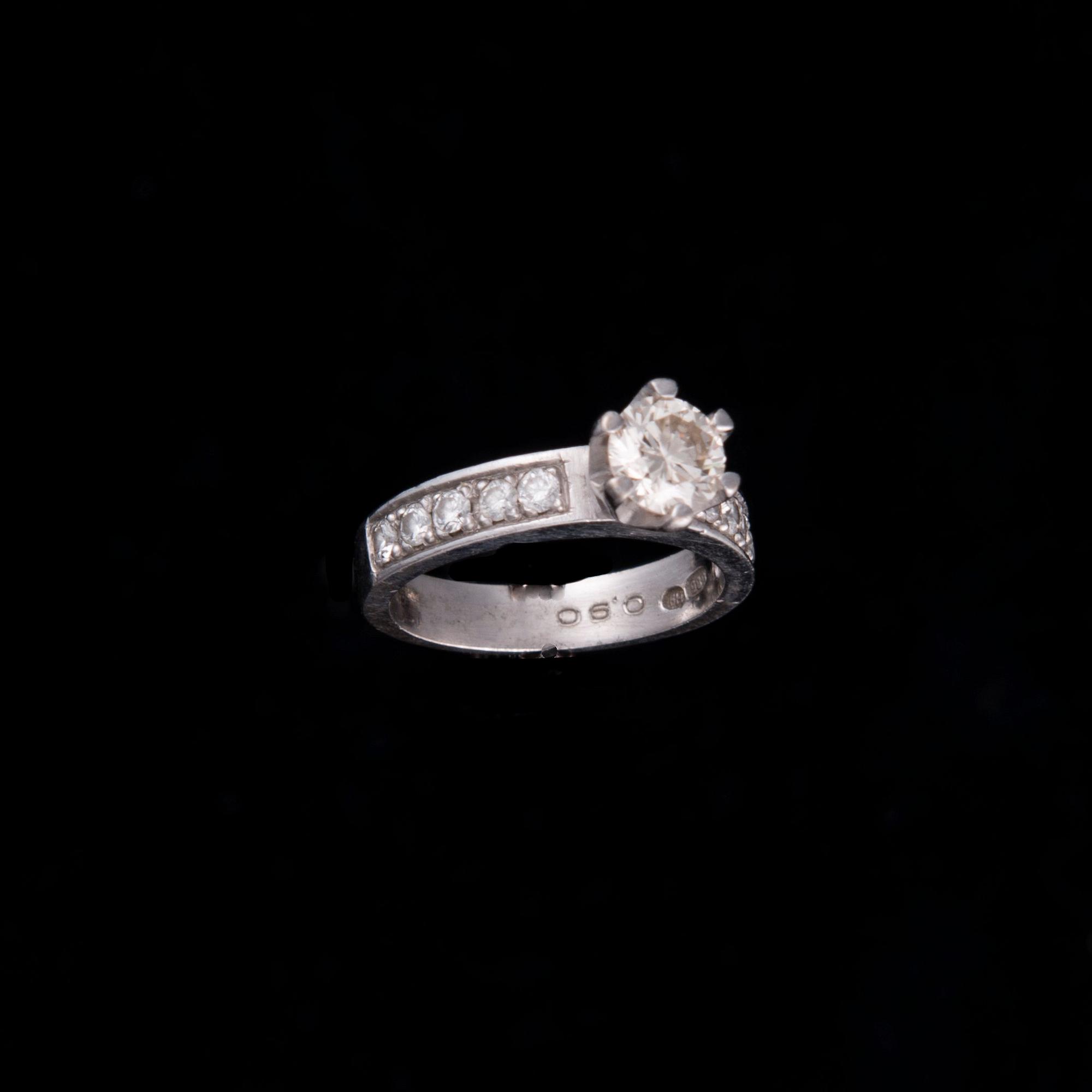 RING, 14K vitguld, briljantslipad diamant ca 0,80 ct, sidostenar tot. ca 0,20 ct. Vikt 5,9 g.