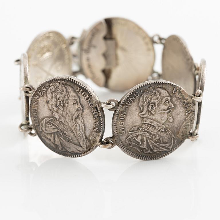 Two bracelets, a brooch, and a pendant with coins.