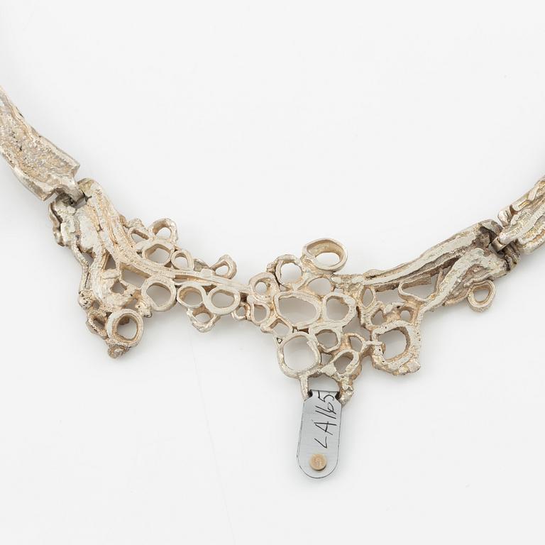 Lars Arby, three neck rings and two pendants, silver with enamel.