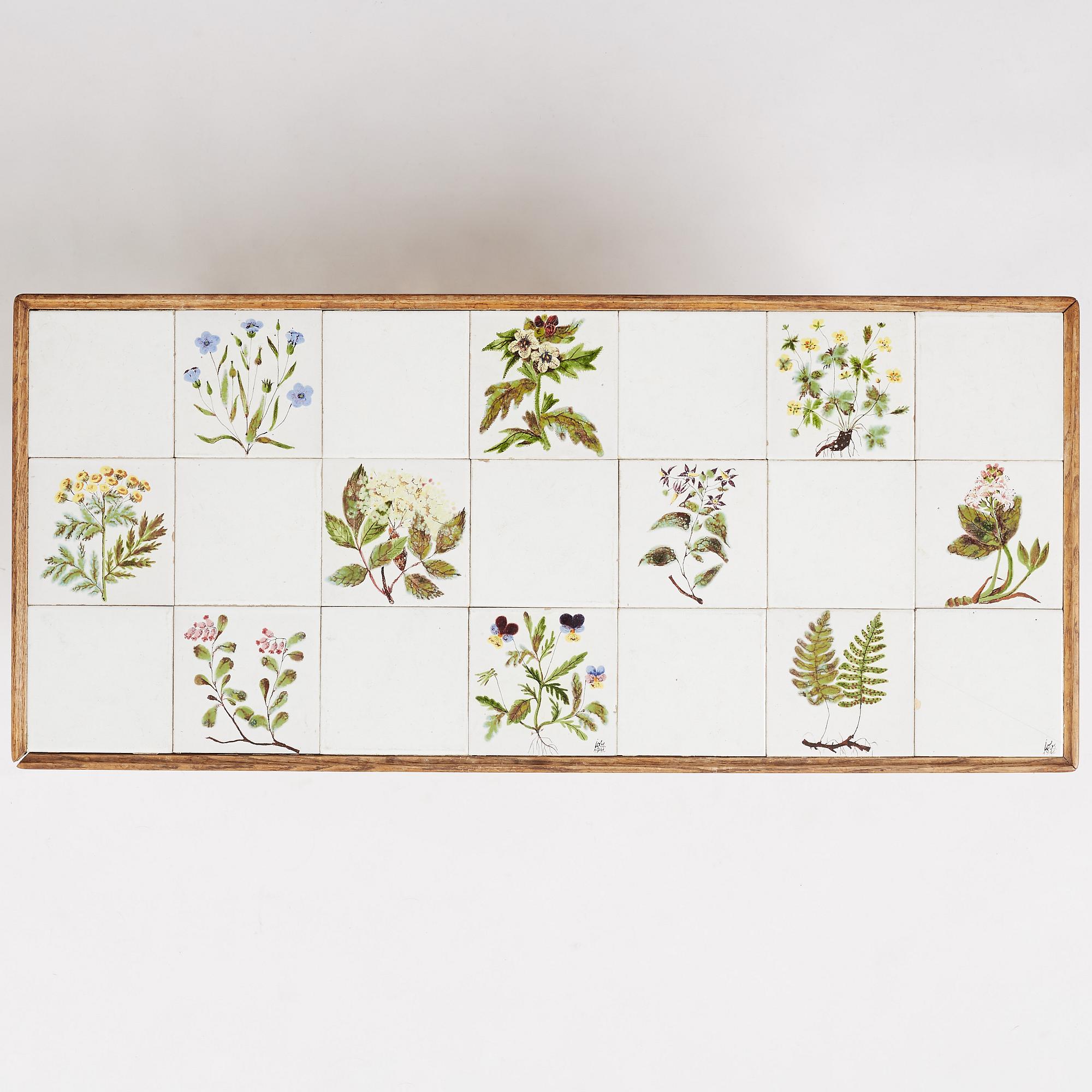 a Swedish Modern coffee table, decorated with Jobs' ceramic tiles, signed and dated 1941.