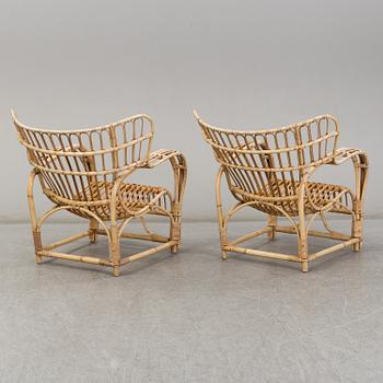 A pair of mid 20th century rattan easy chairs.