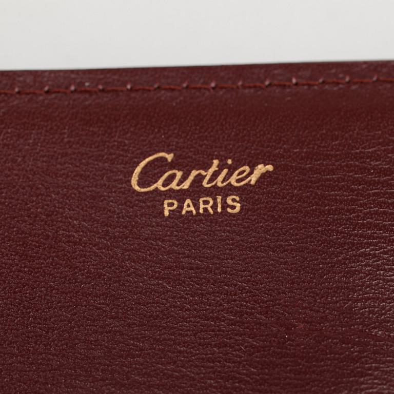CARTIER, a red leather clutch or travel wallet.