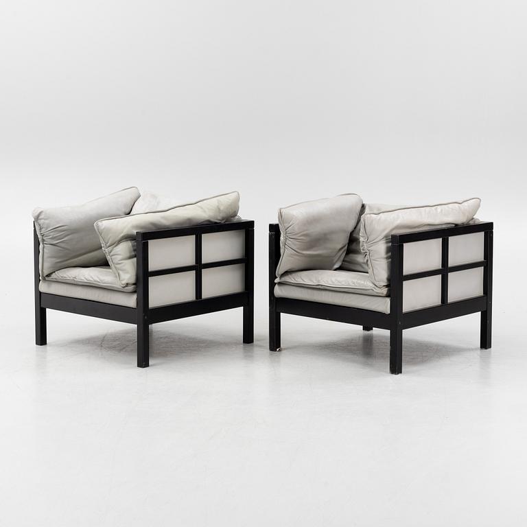 A pair of leather upholstered armchairs. End of the 20th Century.