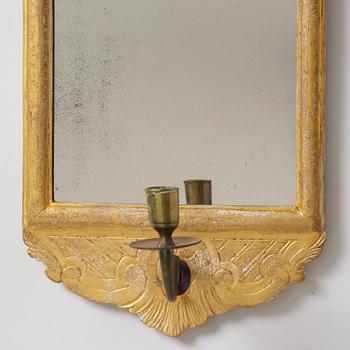 A matched pair of rococo giltwood one-branch girandole mirrors, Stockholm, late 18th century.