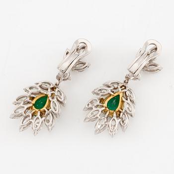 A pair of earrings in 18K white gold with drop-shaped faceted emeralds and diamonds.