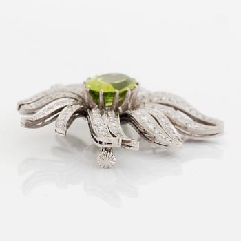 An 18K white gold brooch set with a faceted peridot and eight-cut diamonds.