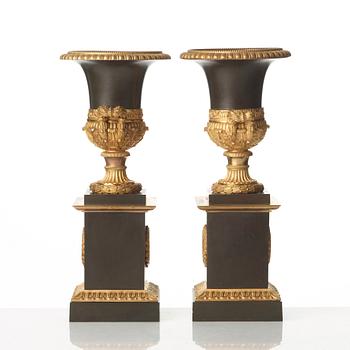 A pair of French Empire early 19th century gilt and patinated bronze urns.