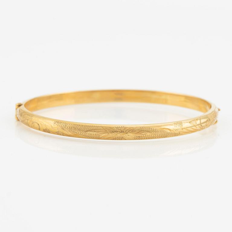 An 18K gold bangle.