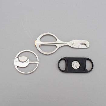 Two cigar cutters from Davidoff and must de Cartier in original cases.