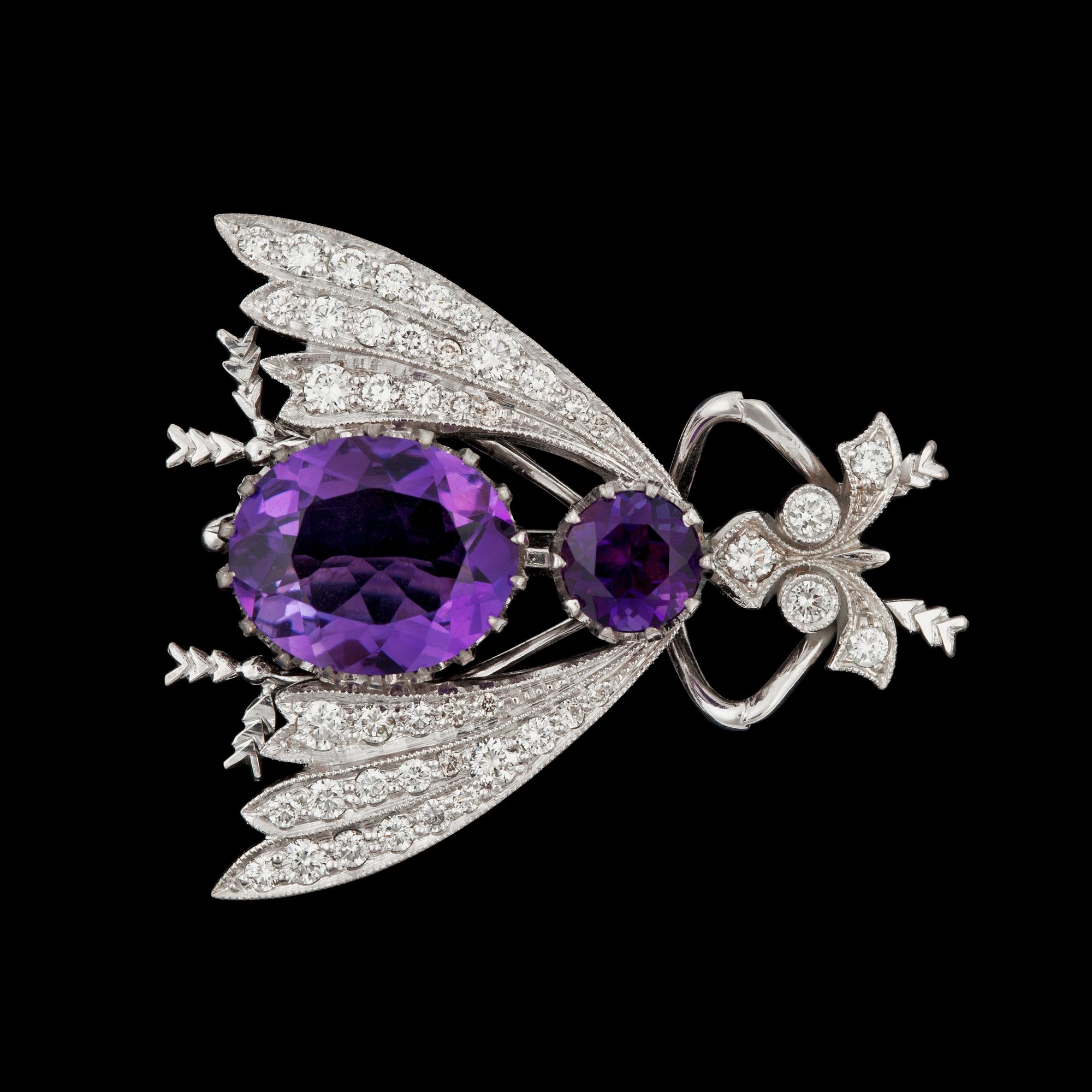 BROSCH/HÄNGE i form av en fluga med briljantslipade diamanter tot ca 0.96 ct samt ametister.
